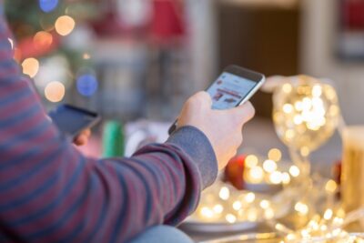 A man is shopping online on iPhone for holidays