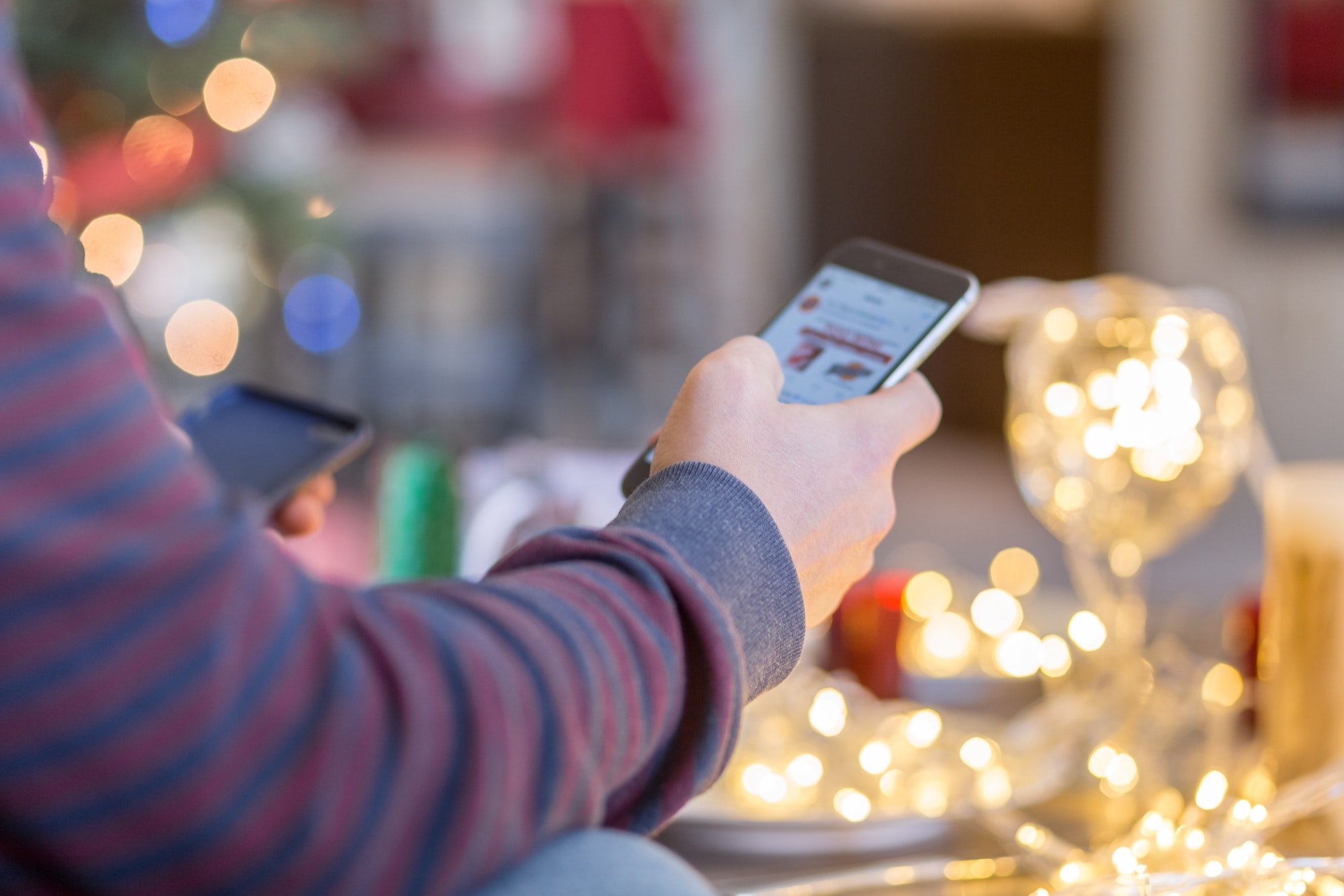 A man is shopping online on iPhone for holidays