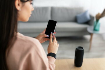 Back view of lady using phone with empty mockup screen