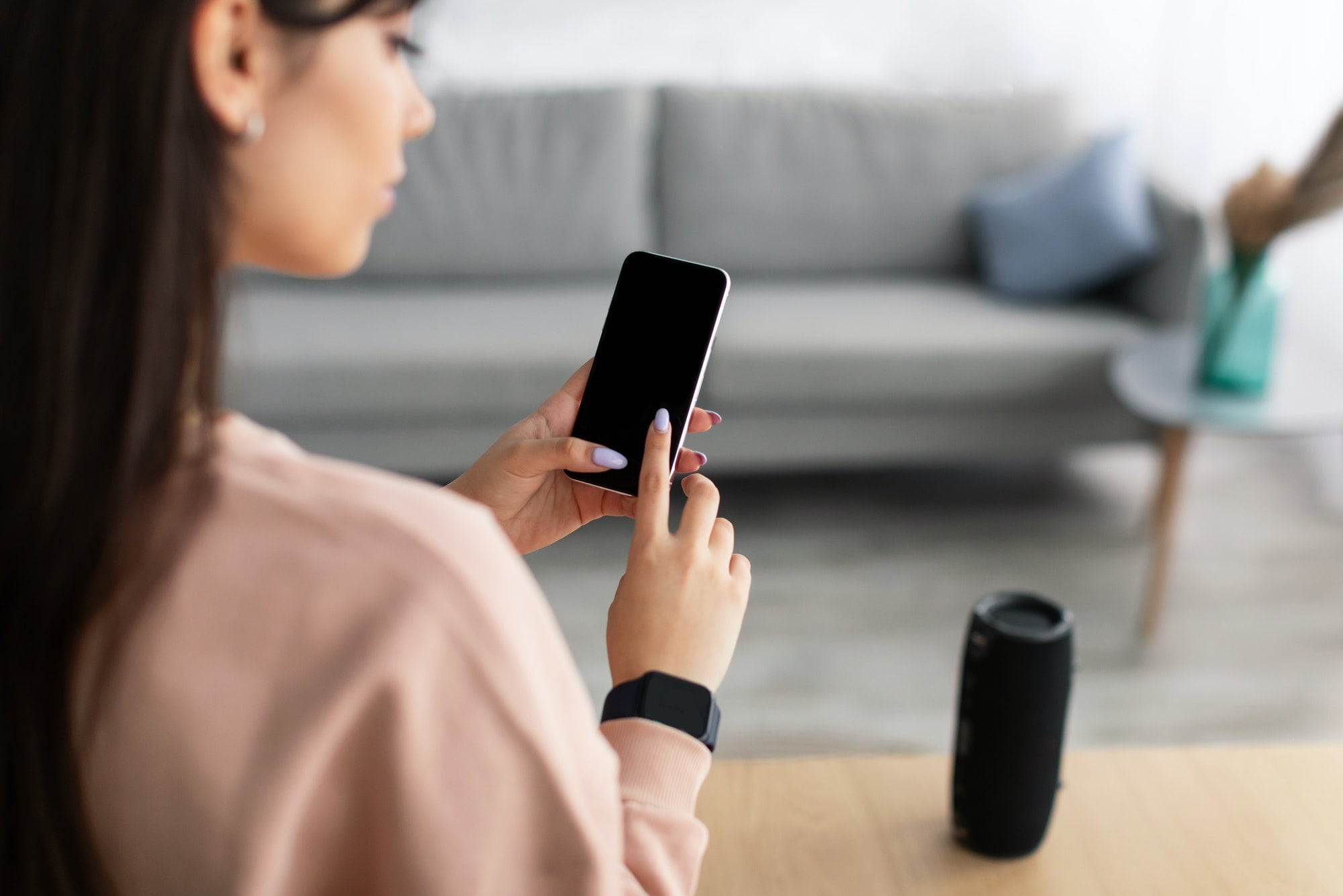 Back view of lady using phone with empty mockup screen