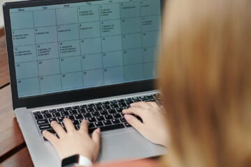 Entrepreneur Filling Calendar on Laptop