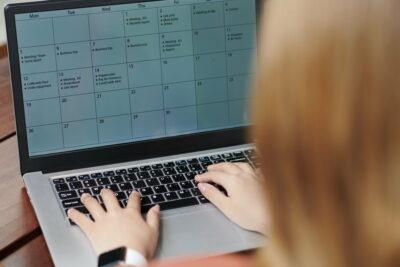 Entrepreneur Filling Calendar on Laptop