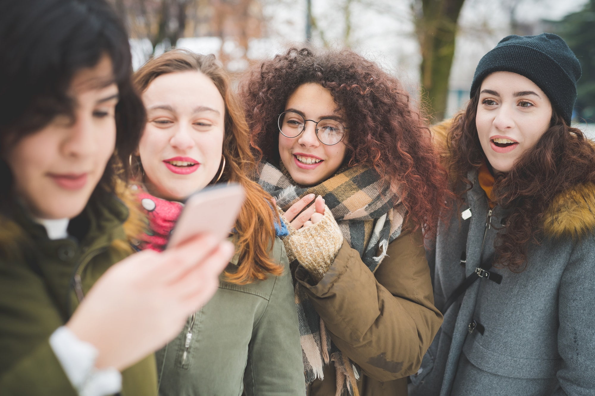 group of young women interacting with smartphone