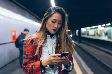 young woman underground using smart phone