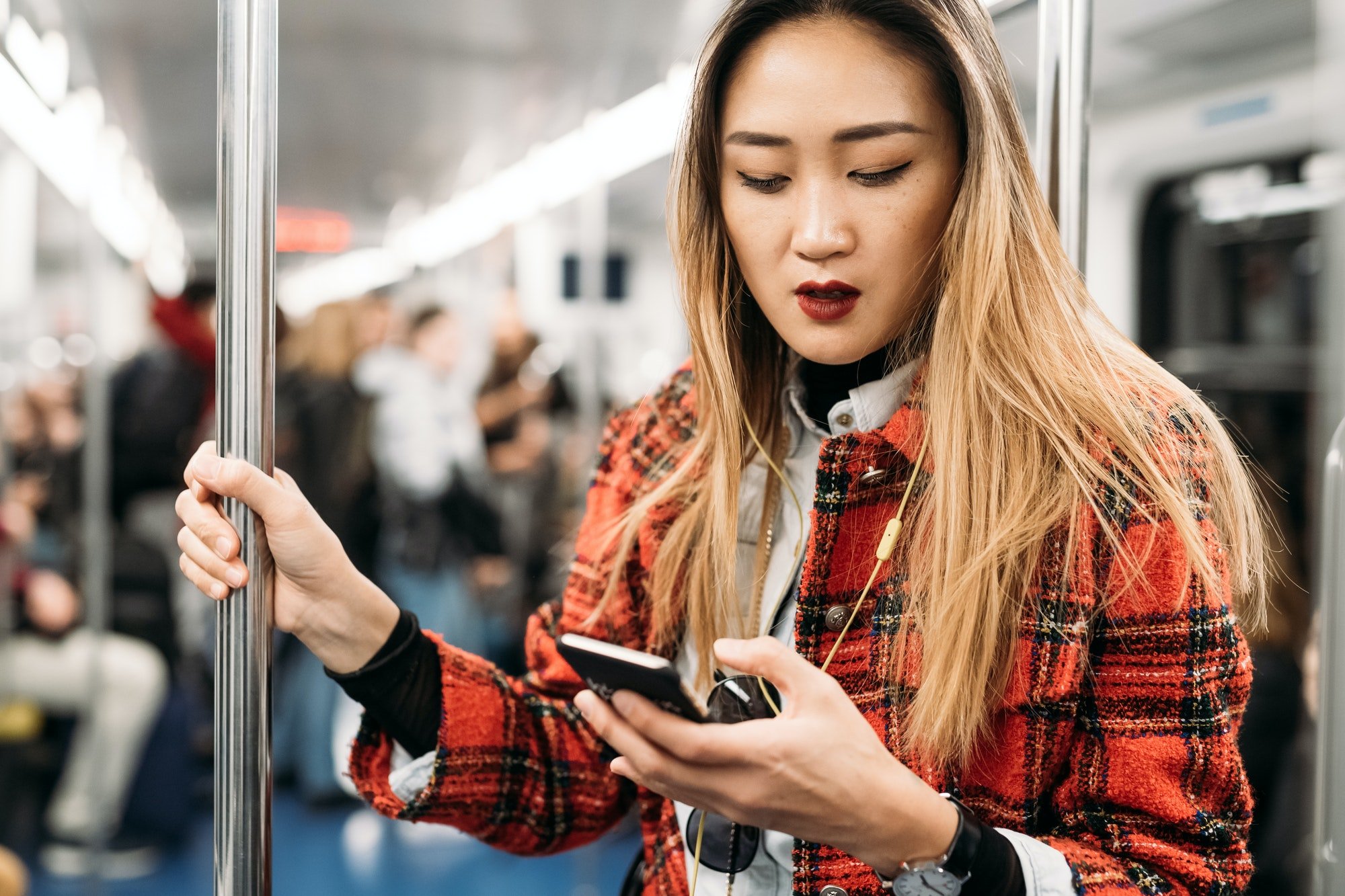 young woman underground using smart phone