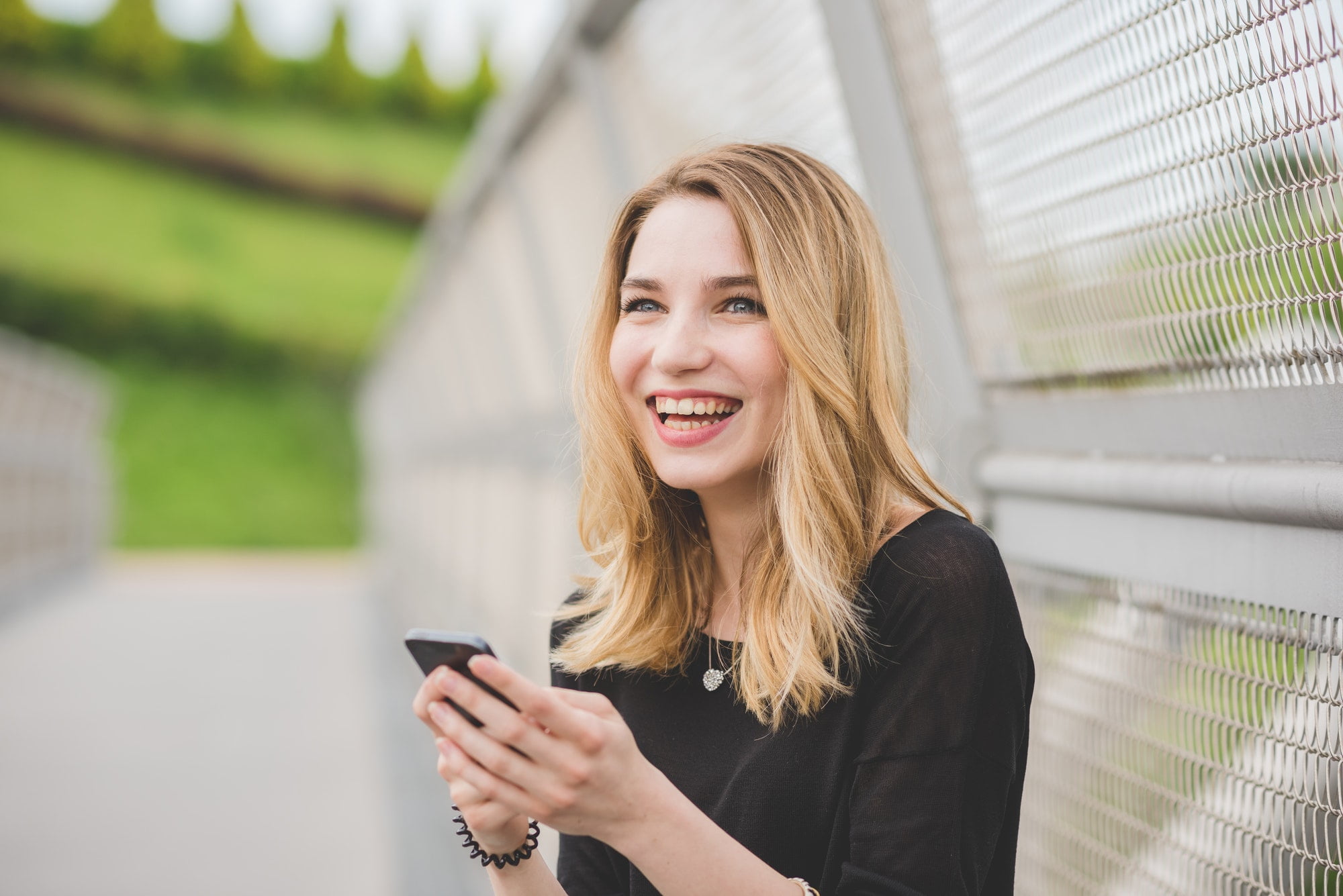 Young woman using smartphone laughing