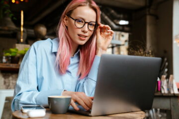 Young woman working with laptop while sitting in cafe