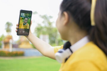 A young woman taking a selfie with a smartphone.