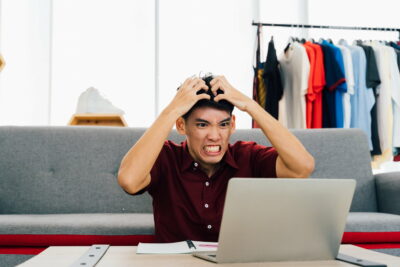 Angry remote worker watching laptop at home