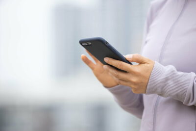 Asian woman using smartphone outdoors