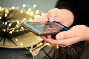 Close up female hands holding a phone gadget with photo gallery open