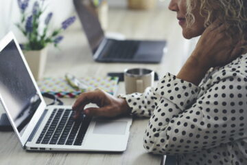 Close up of woman using laptop on the desk in home office workstation. Modern female people