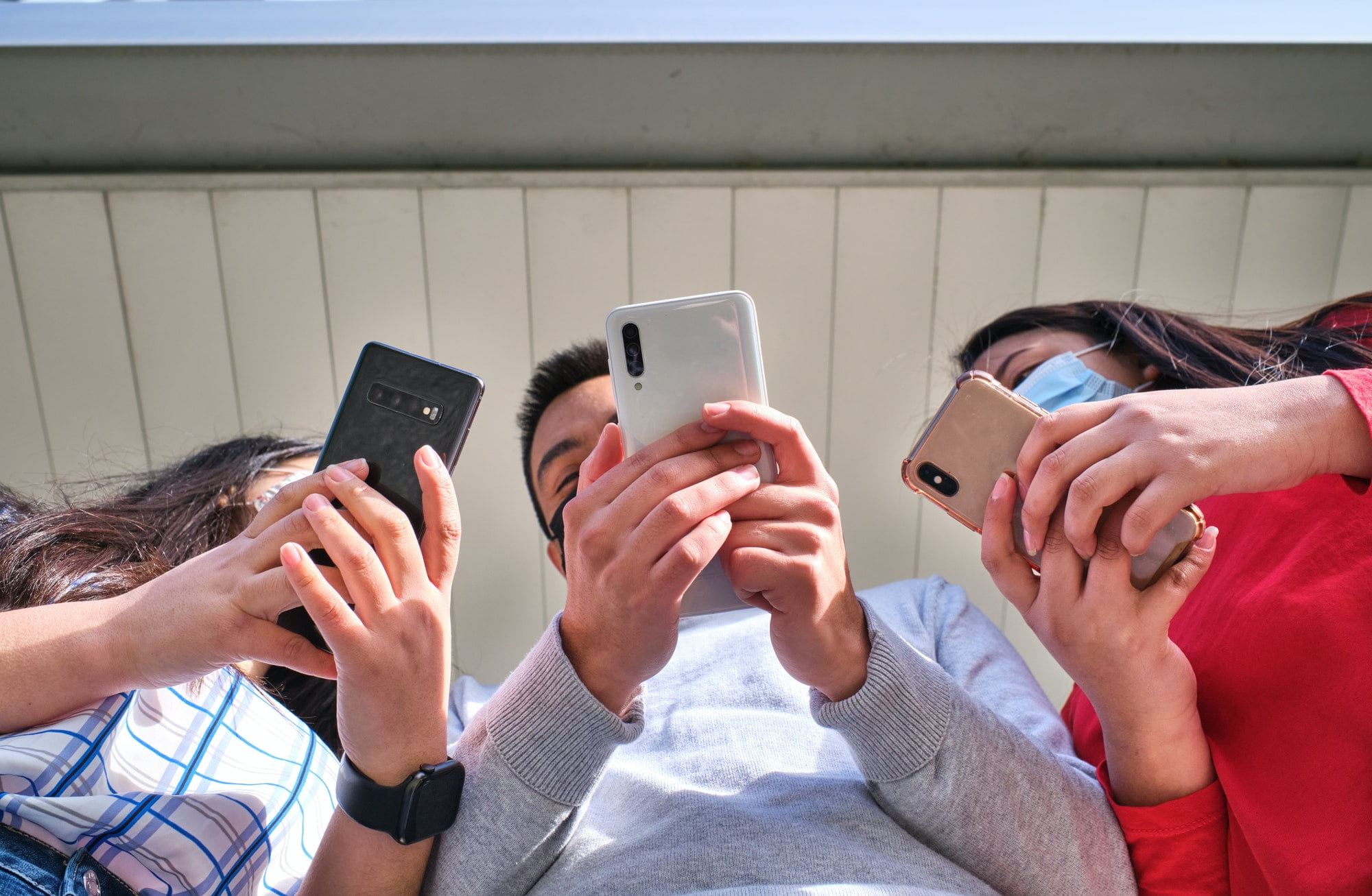 group of young people using their smartphones