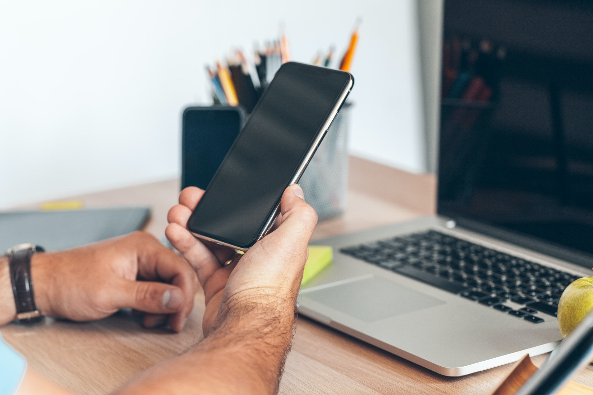 Man using mobile smart phone. Business man hands using cell phone at office desk