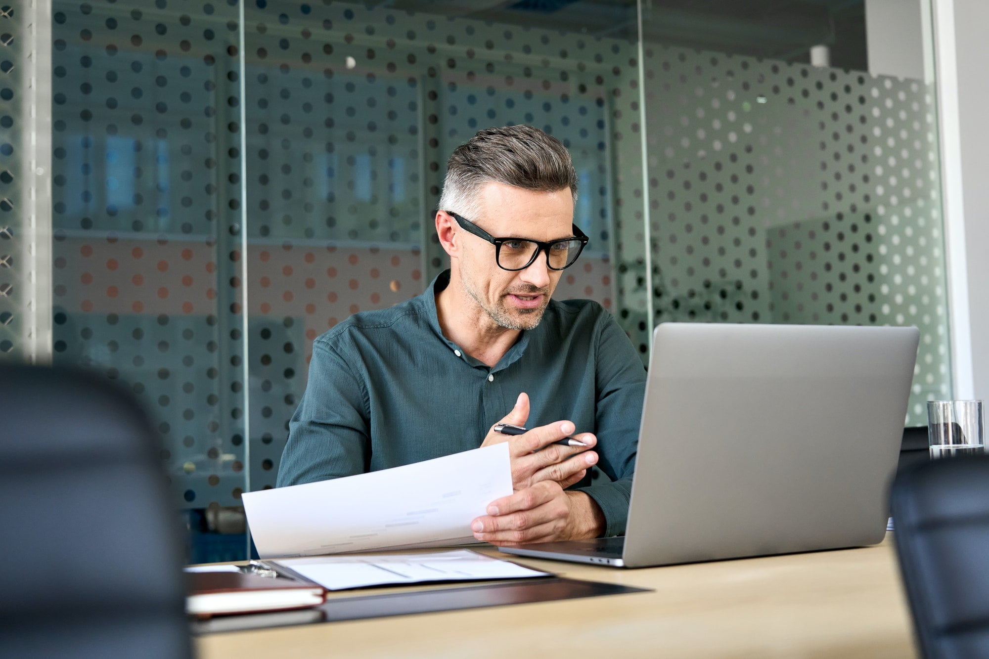 Mature businessman using laptop talking on video call virtual meeting.