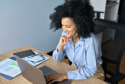 Smiling African American businesswoman working typing using pc laptop.