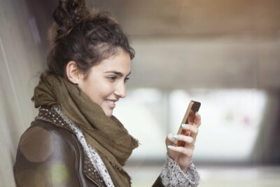 Smiling young woman with smartphone