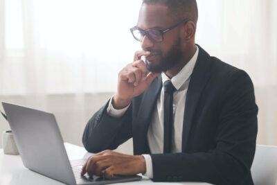 Close up of thoughtful manager reading emails on laptop