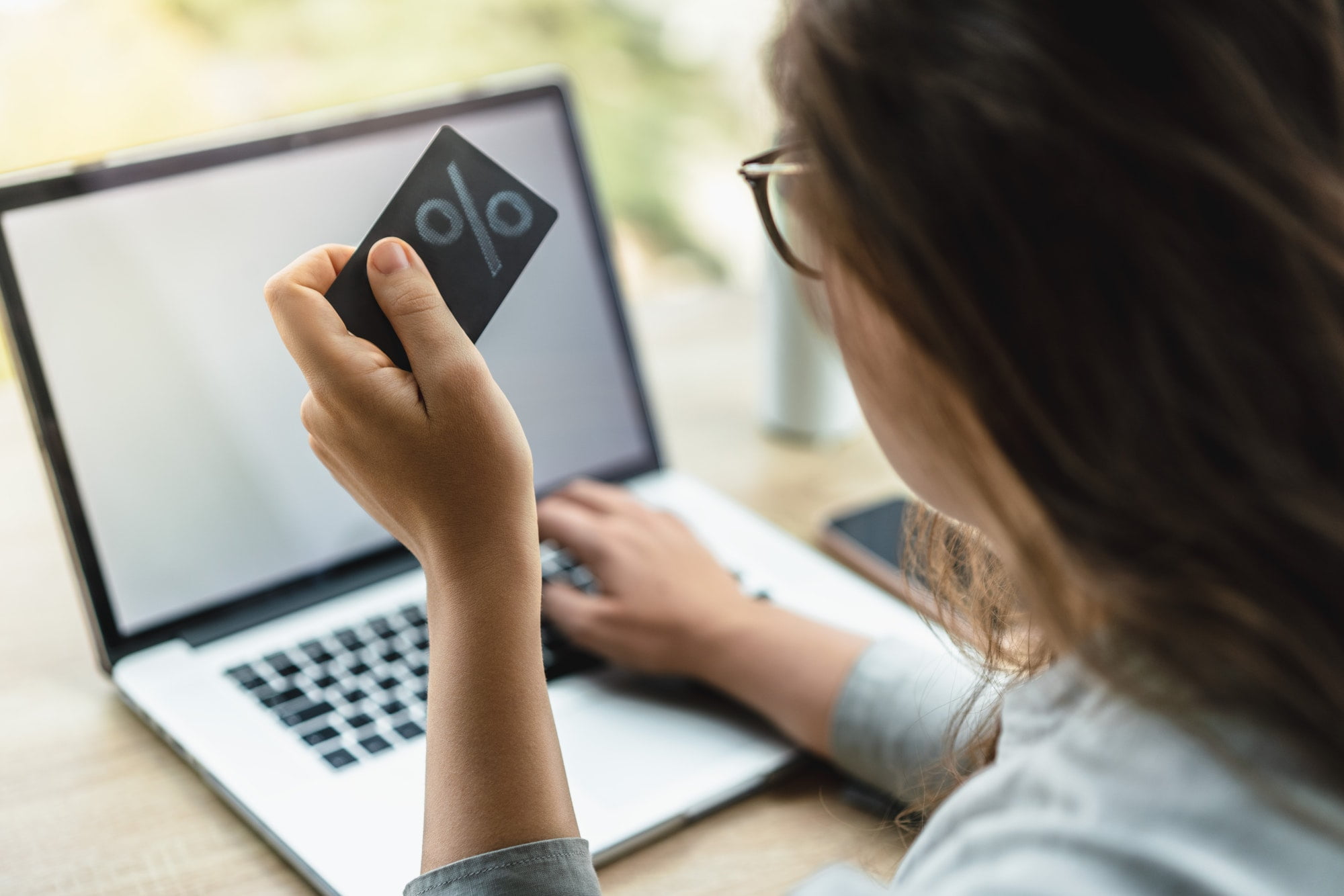 Woman shopping online with laptop holding a credit card