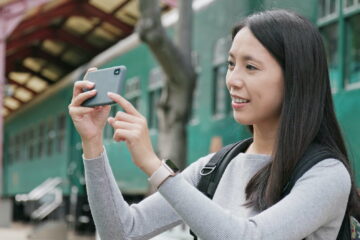 Woman traveler using smart phone for taking photo and video