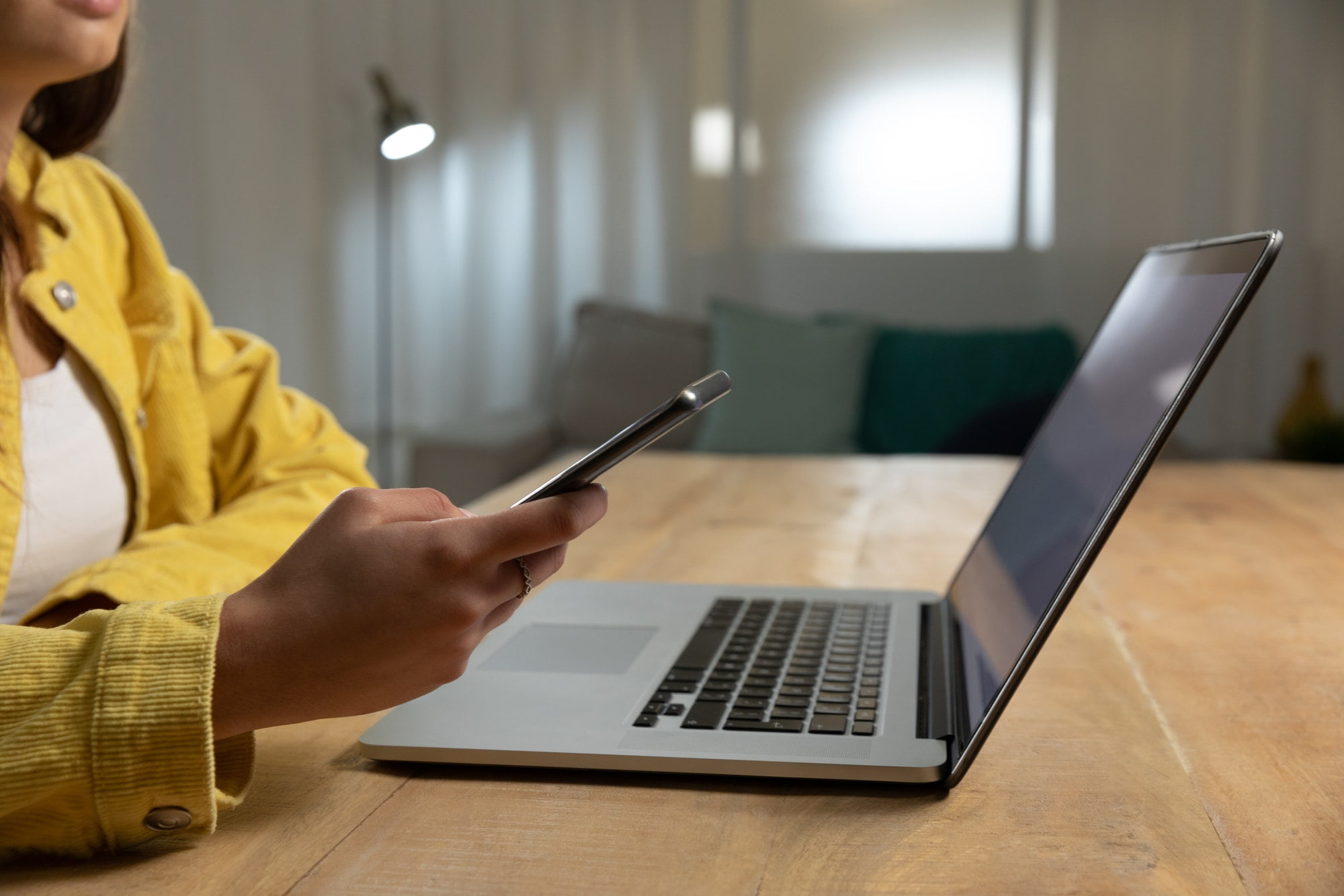 Young woman using laptop computer and smartphone