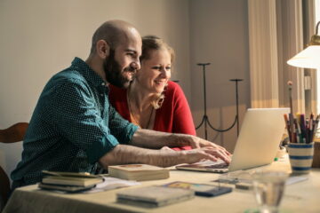 A man and a woman in front of a laptop