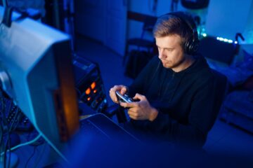 Gamer with joystick playing videogame on console