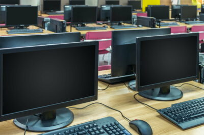 Many rows of computer in Computer Lab, focus on first LCD monitor