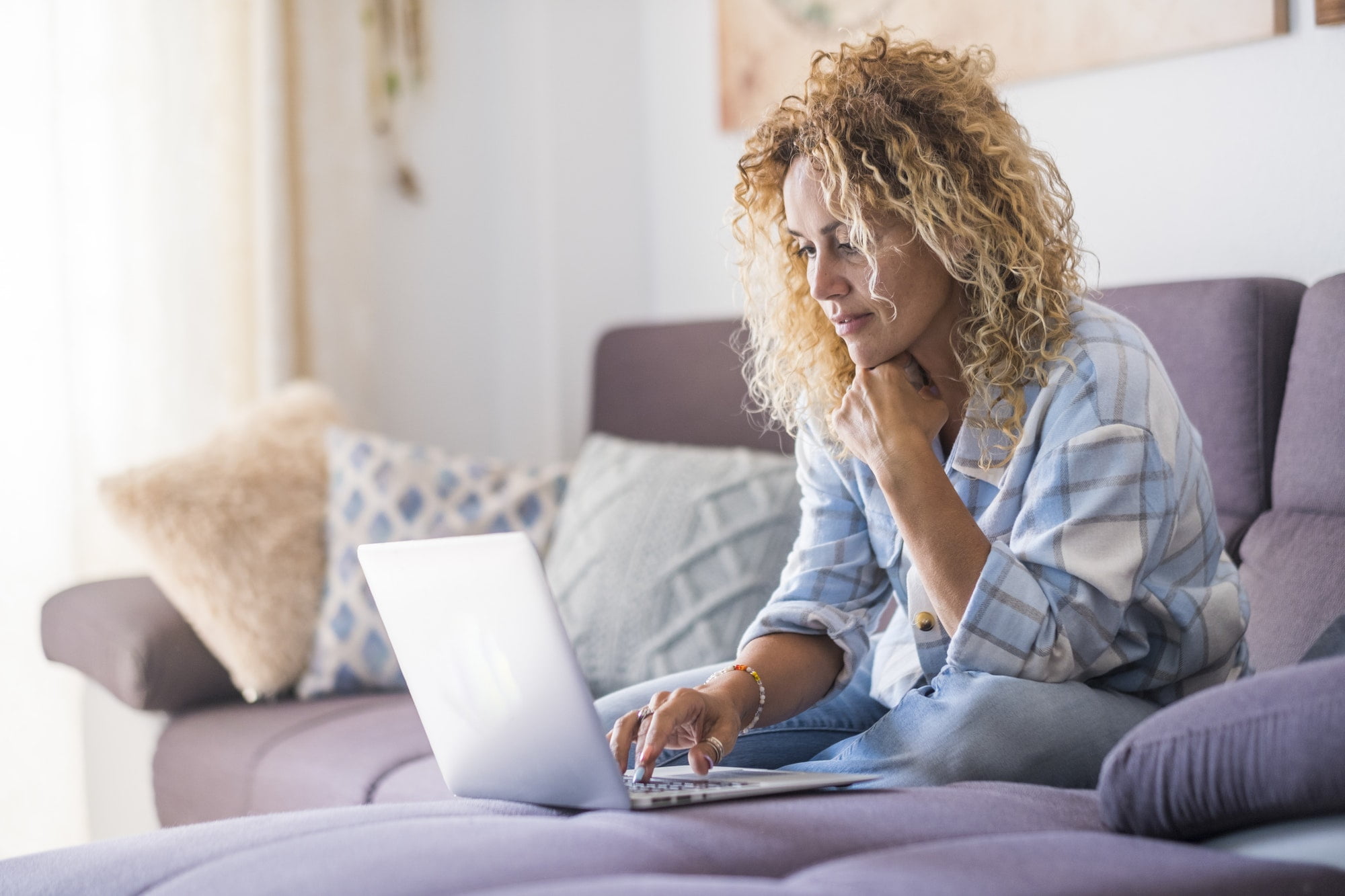 Smiling caucasian adult hipster sit relax on couch using modern laptop browsing internet