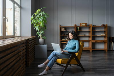 Young woman freelancer work on laptop at home typing email to client or shopping in internet store