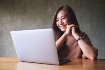 A beautiful young asian woman using laptop computer for video call at home