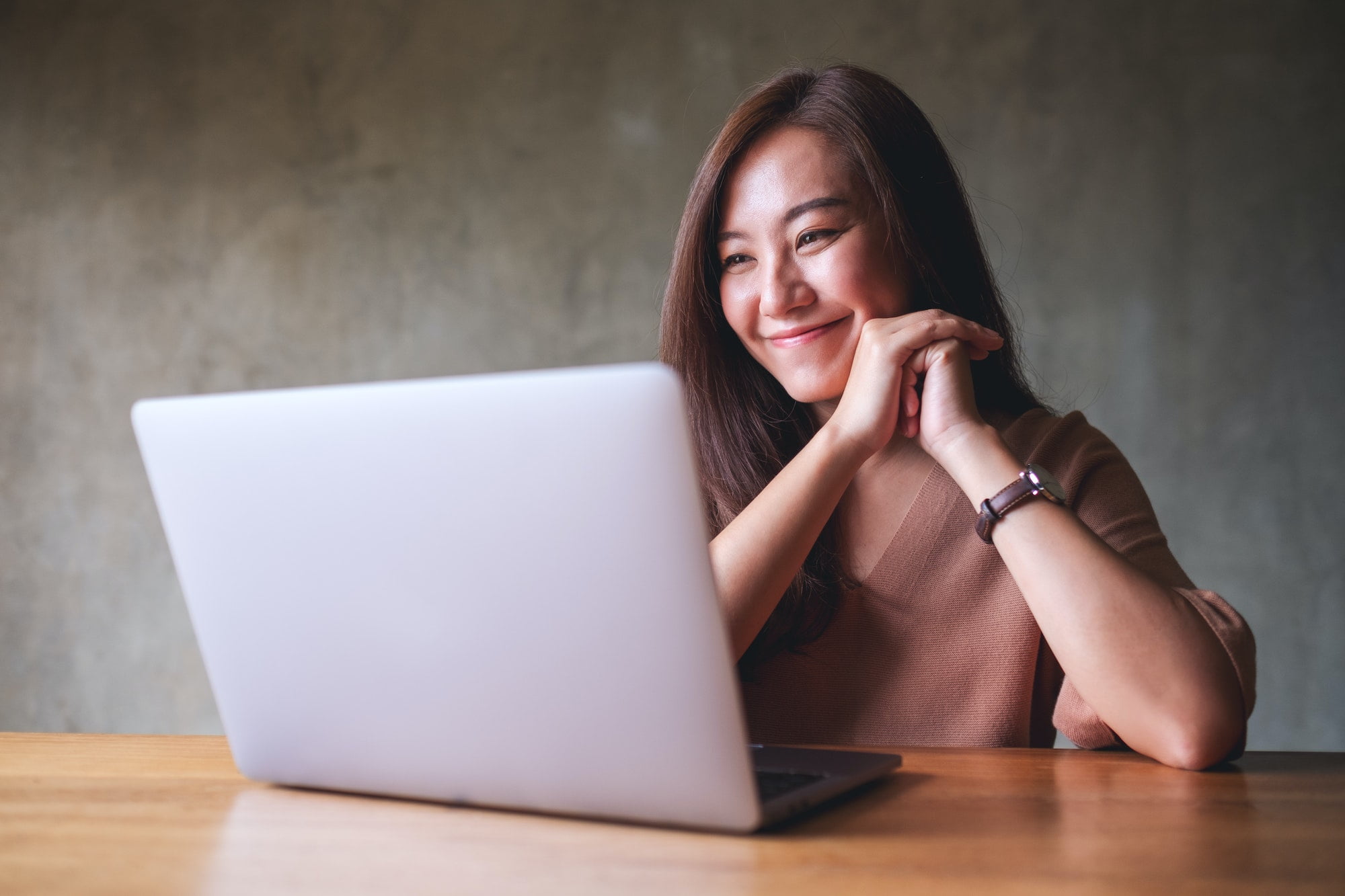 A beautiful young asian woman using laptop computer for video call at home