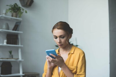 beautiful young woman using smartphone at home