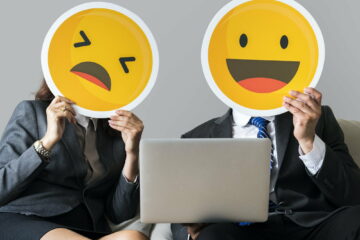 Cheerful people holding emoticon icon