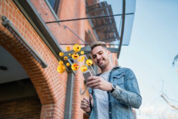 man using smartphone sending emojis.