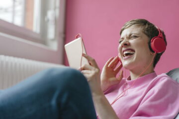 Screaming woman with cell phone and headphones listening to music