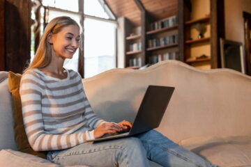 Smiling woman working on laptop at home