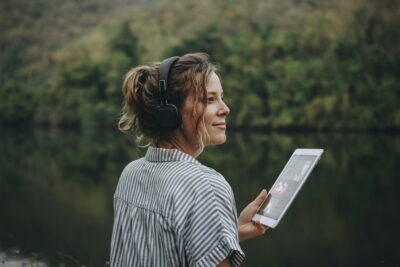 Woman alone in nature listening to music with headphones