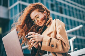 woman in glasses opens laptop and working