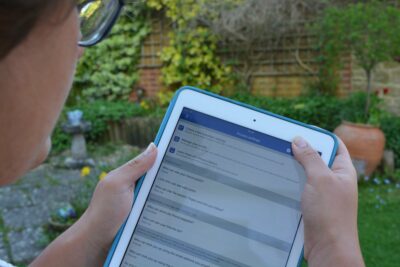 Young woman with a tablet, checking privacy settings on Facebook