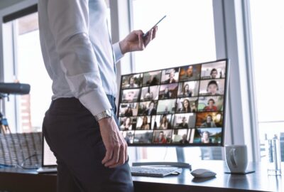 Businessman with his team on video chat computer screen, using phone