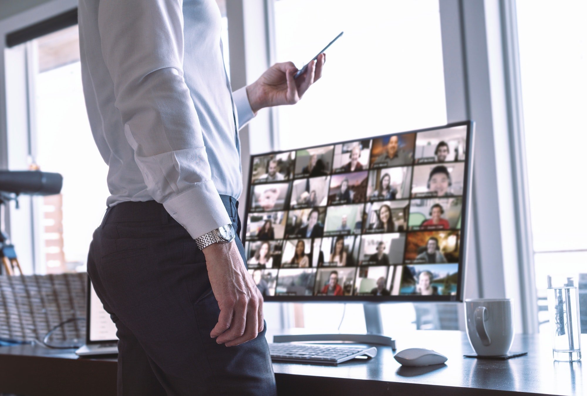 Businessman with his team on video chat computer screen, using phone