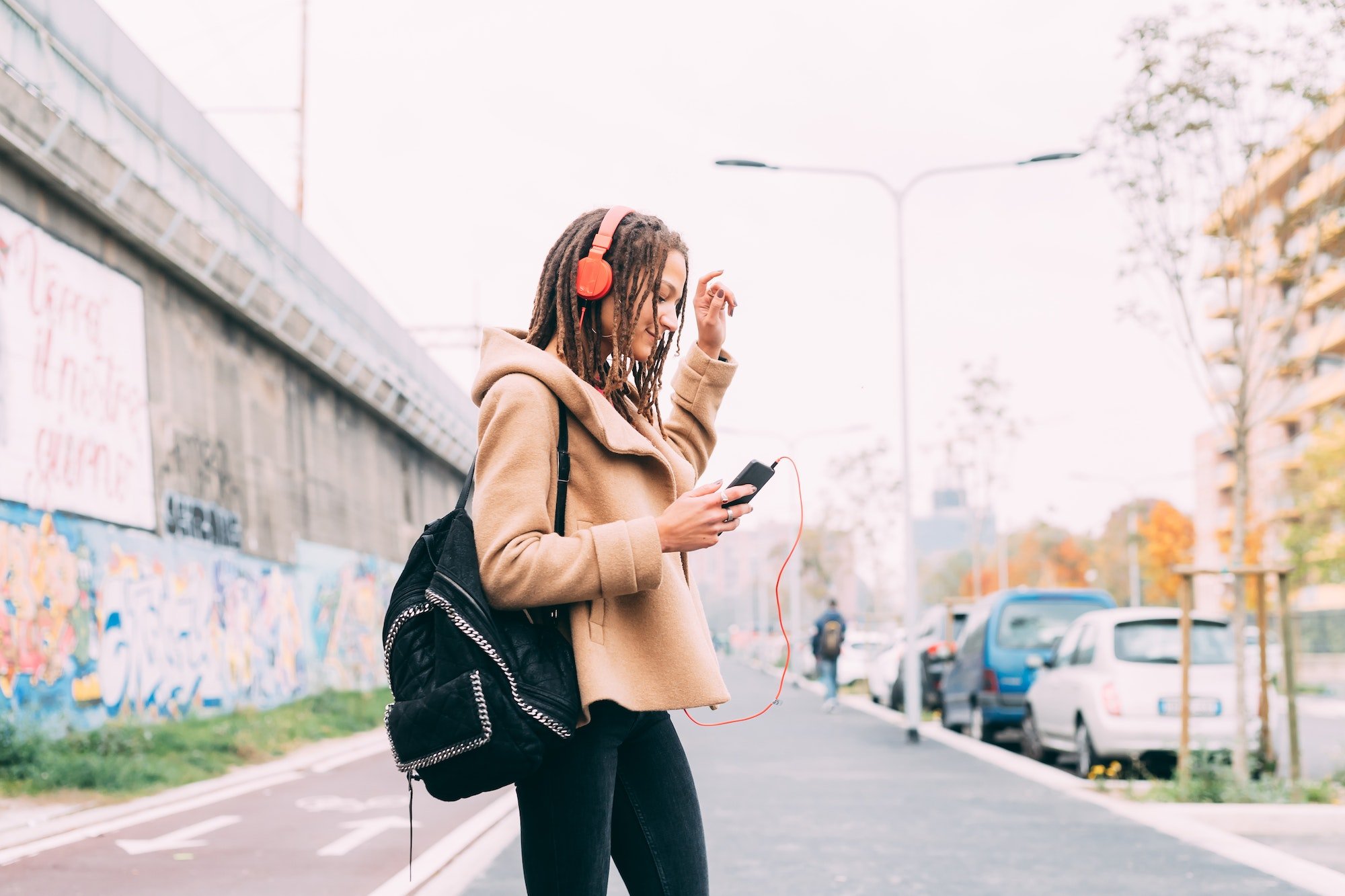 young woman outdoors listening music smart phone