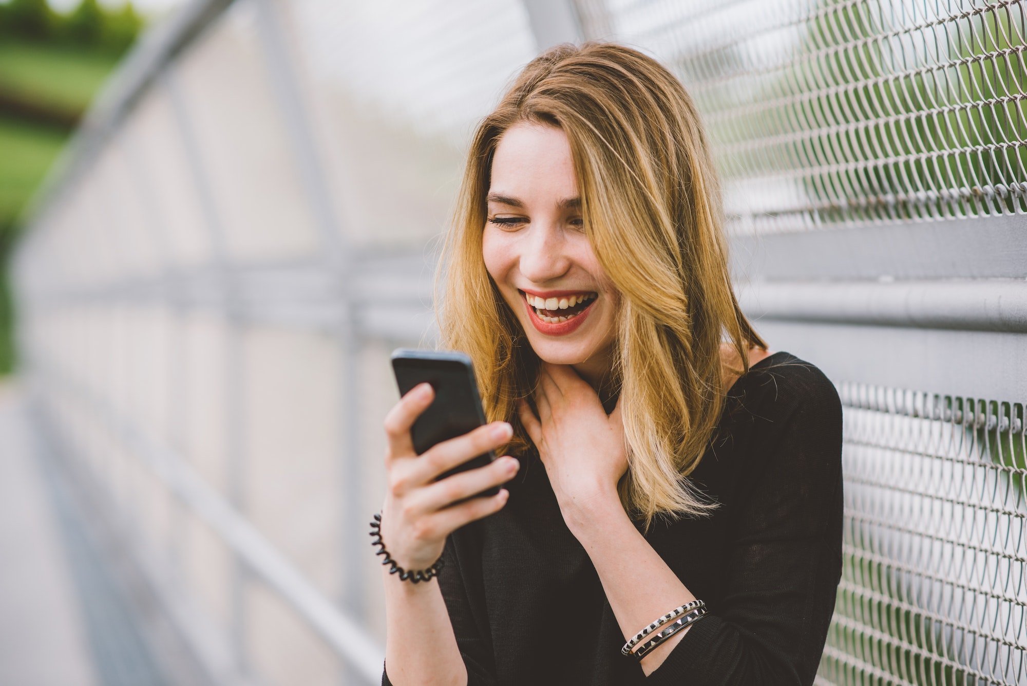 Young woman using smartphone laughing