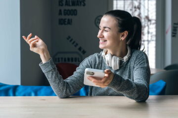 A young woman in white headphones and with a smartphone.