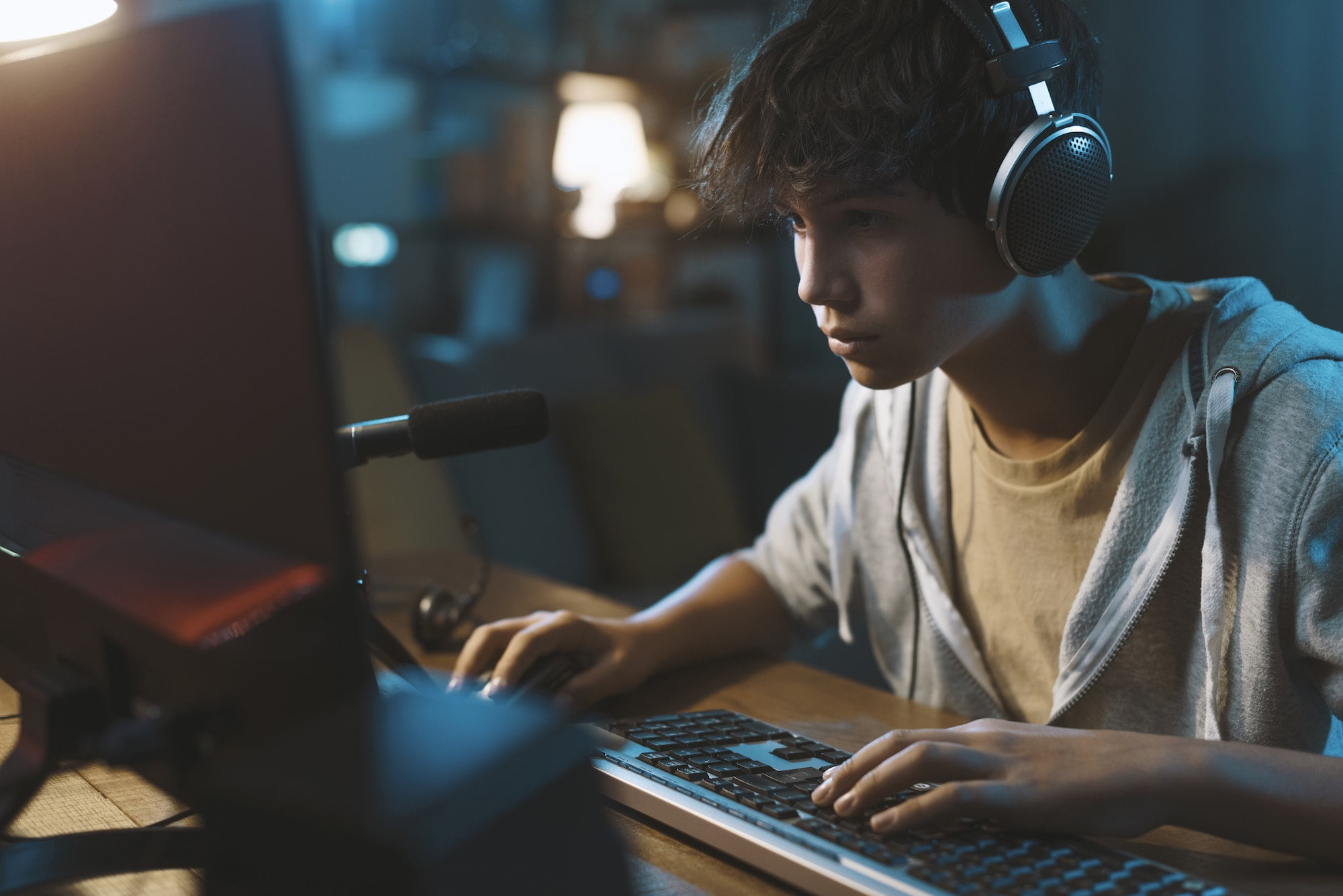 Teenager wearing headphones and playing online video games