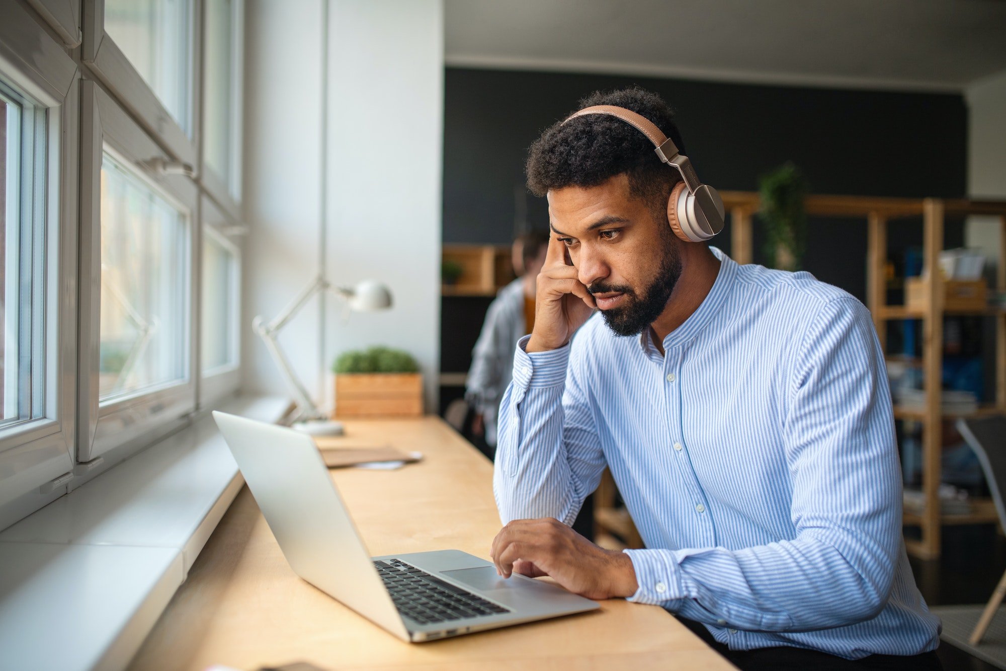 Young African-american teacher with headset and laptop indoors in staffroom