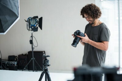 Male photographer reviewing captured photos in his digital camera