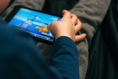 Boy playing video game on smartphone at home