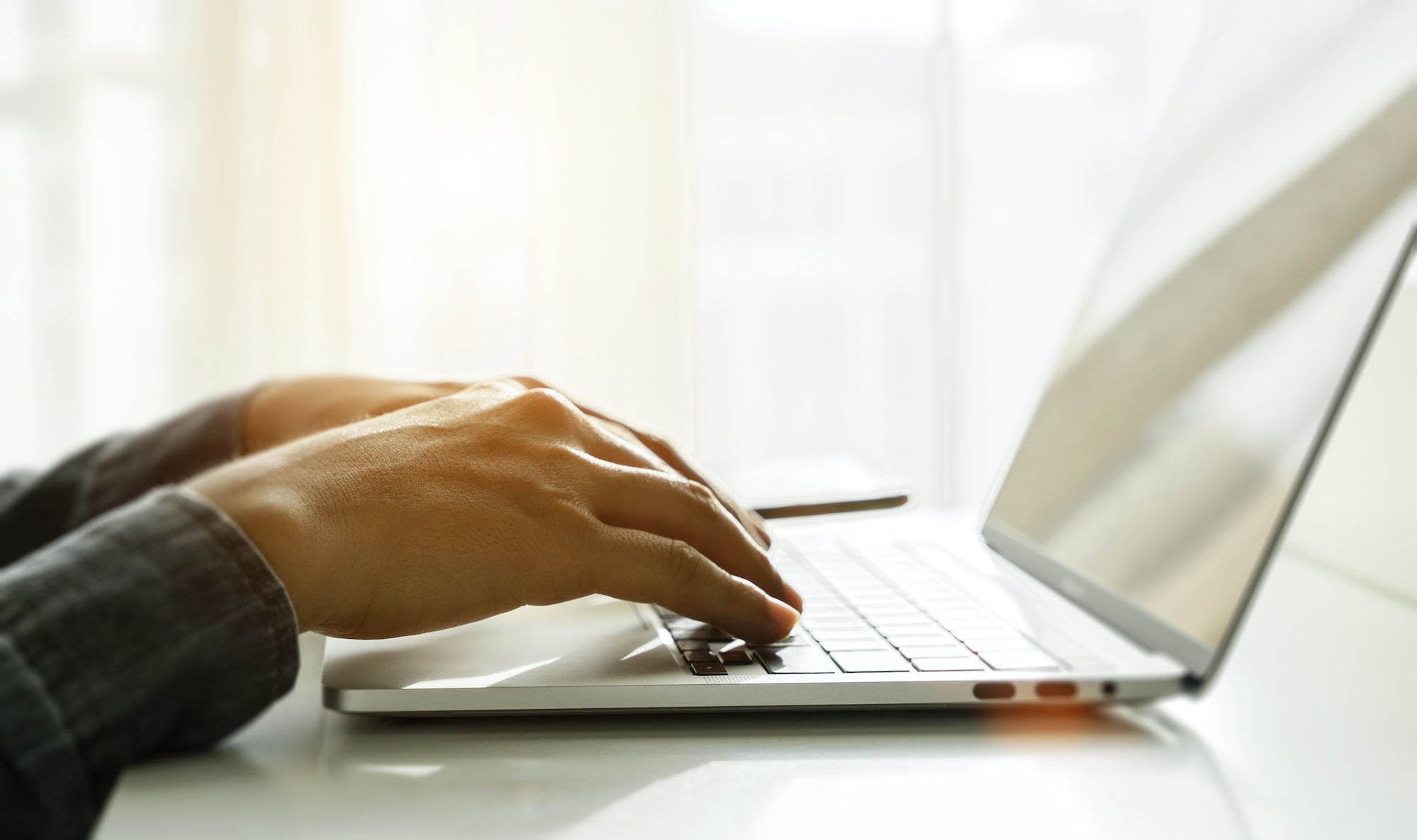 Close up of man hands using laptop at home office. Concept of searching web, browsing information